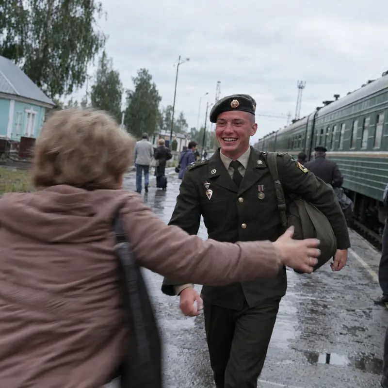Солдат в парадной форме бежит по перрону навстречу маме